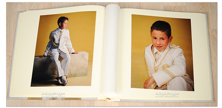 Álbum tradicional de Primera Comunión abierto con fotografías de estudio