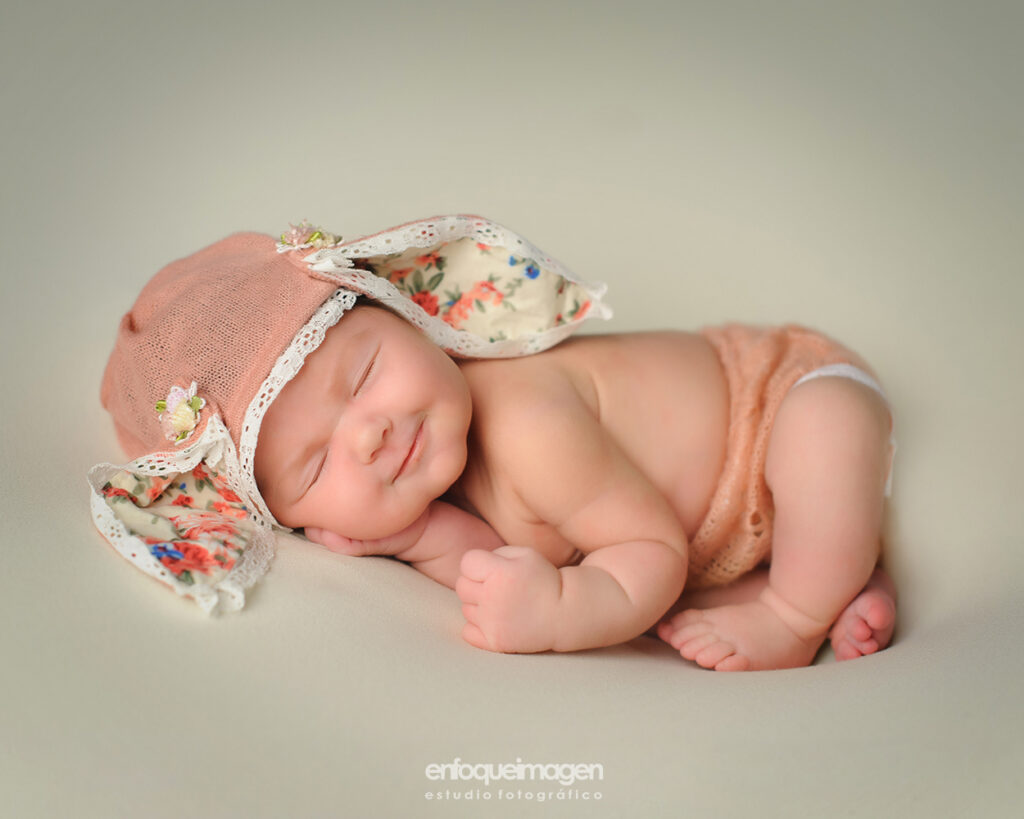 fotografia niña recien nacida sonriendo con gorro de conejo