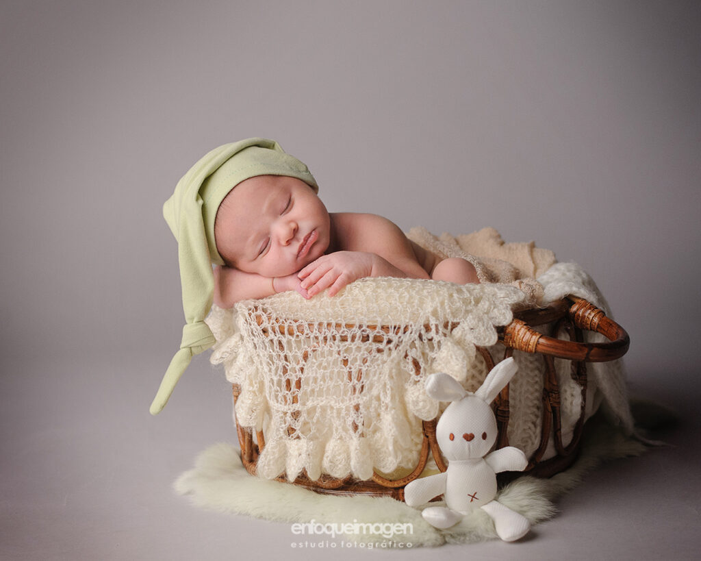 fotografia de bebe dormido en cesto de madera